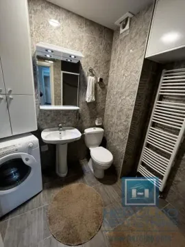 Compact bathroom with a washbasin, toilet, washing machine, and towel radiator. - image 18