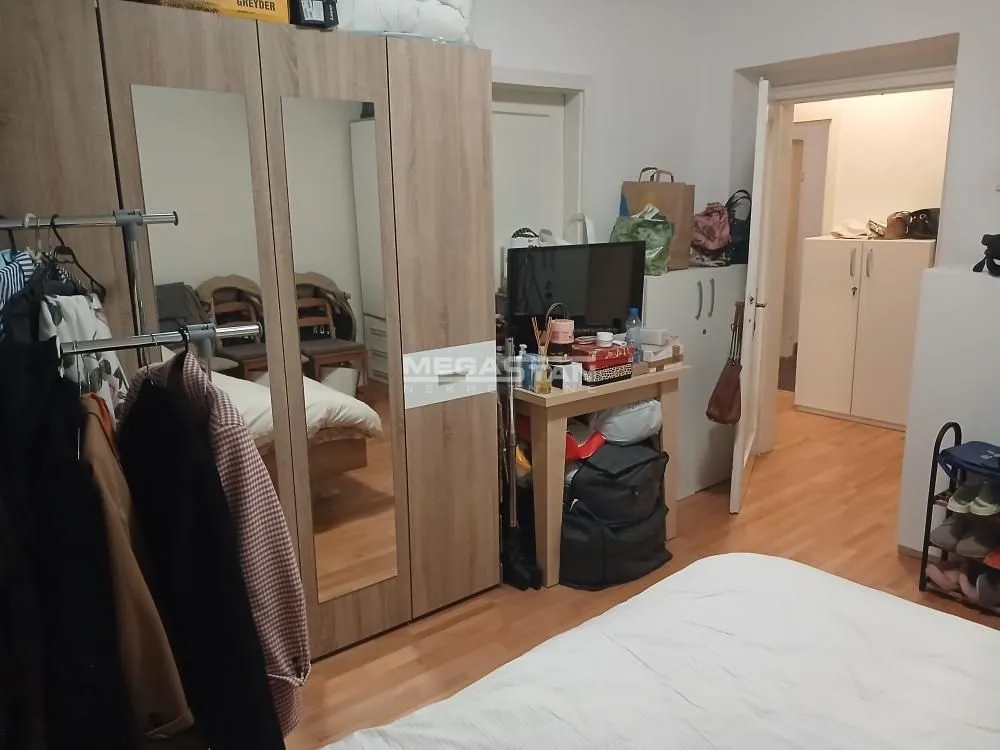 Nameštena spavaća soba sa velikim ormarom sa ogledalom i krevetom.