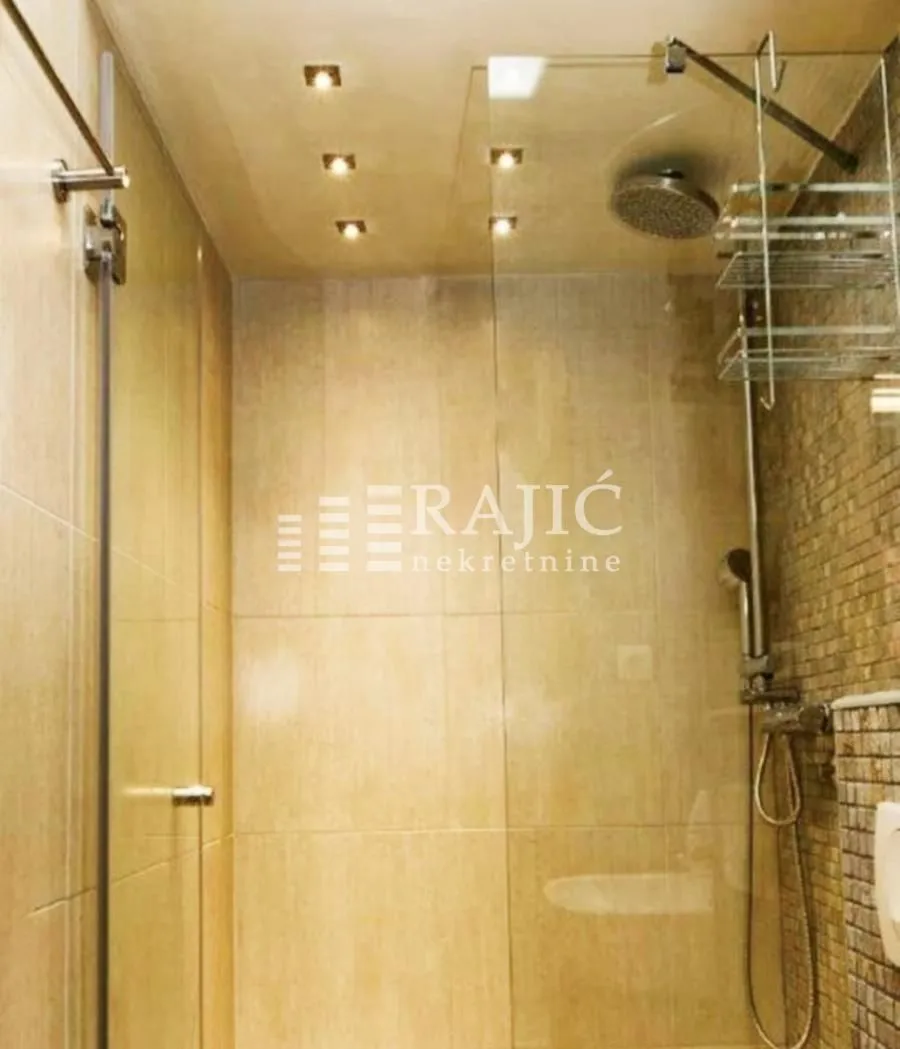 Modern bathroom with a walk-in shower and recessed lighting.