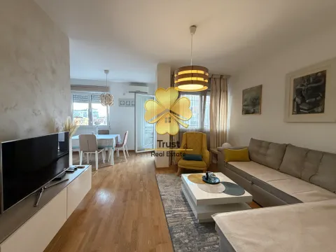 Dnevna soba sa garniturom, TV-om i trpezarijom u pozadini. - image 2