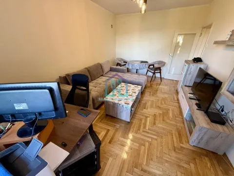 Dnevna soba sa garniturom, radnim stolom i parketom na podu. - image 4