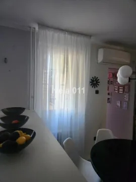 Manja kuhinja sa trpezarijskim stolom i prozorom prekrivenim belom zavesom. - image 7