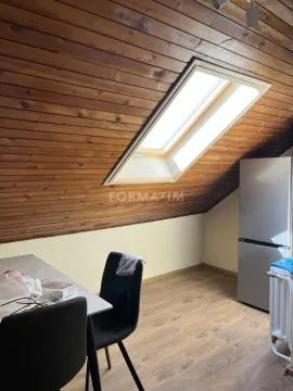 Attic space with wooden ceiling cladding, dining table and refrigerator. - image 7