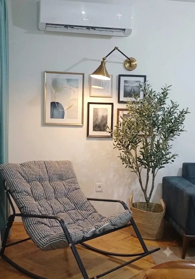 Udoban dnevni boravak sa foteljom za ljuljanje i ukrasnim biljkama.