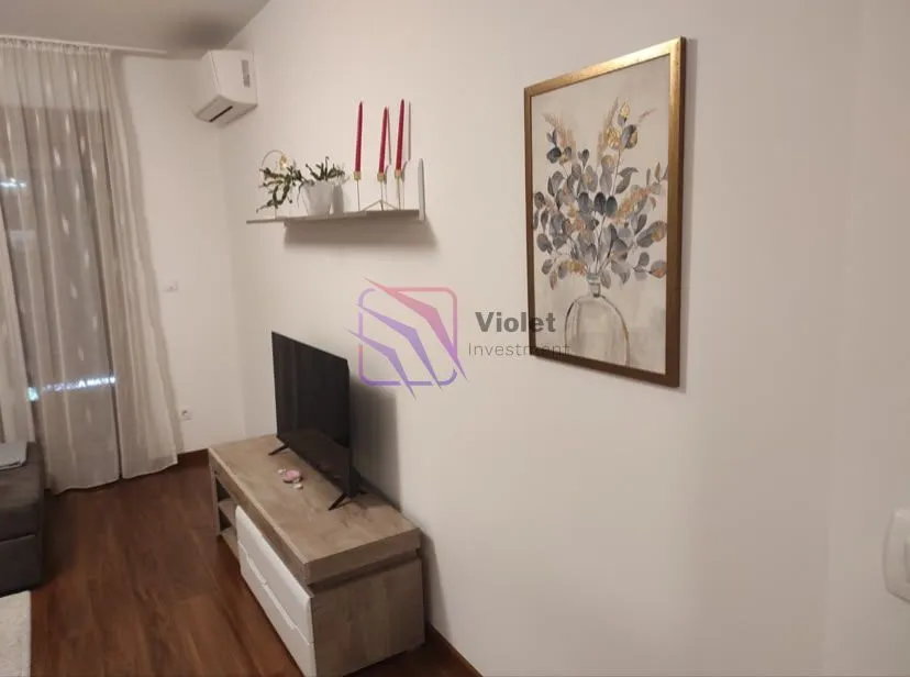Living room with a TV, media console, and decorative wall painting.