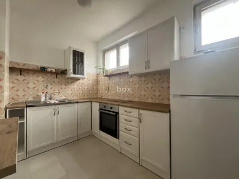 Kitchen equipped with white cabinets, stove, and refrigerator. - image 5