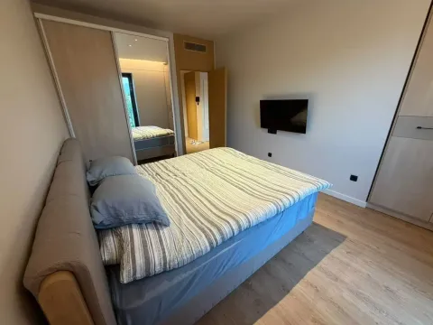 Namještena spavaća soba sa bračnim krevetom, plakarima i zidnim televizorom. - image 9