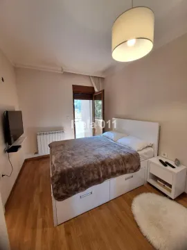 Nameštena spavaća soba sa bračnim krevetom, noćnim stočićem, televizorom i izlazom na terasu. - image 17