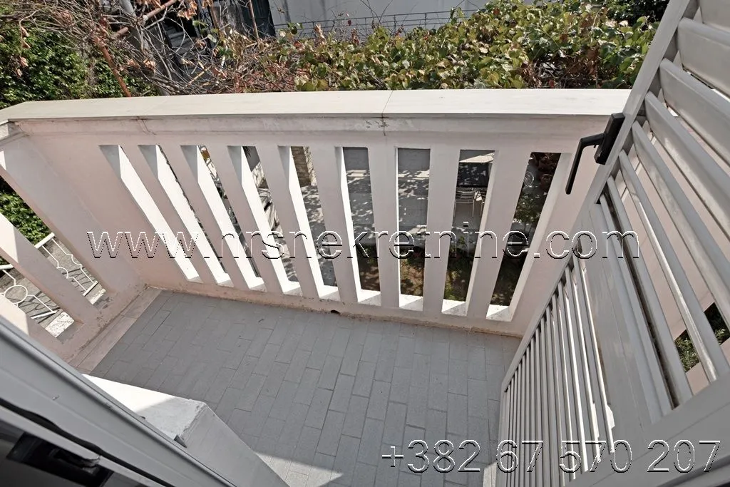 View of a small balcony with a white railing.