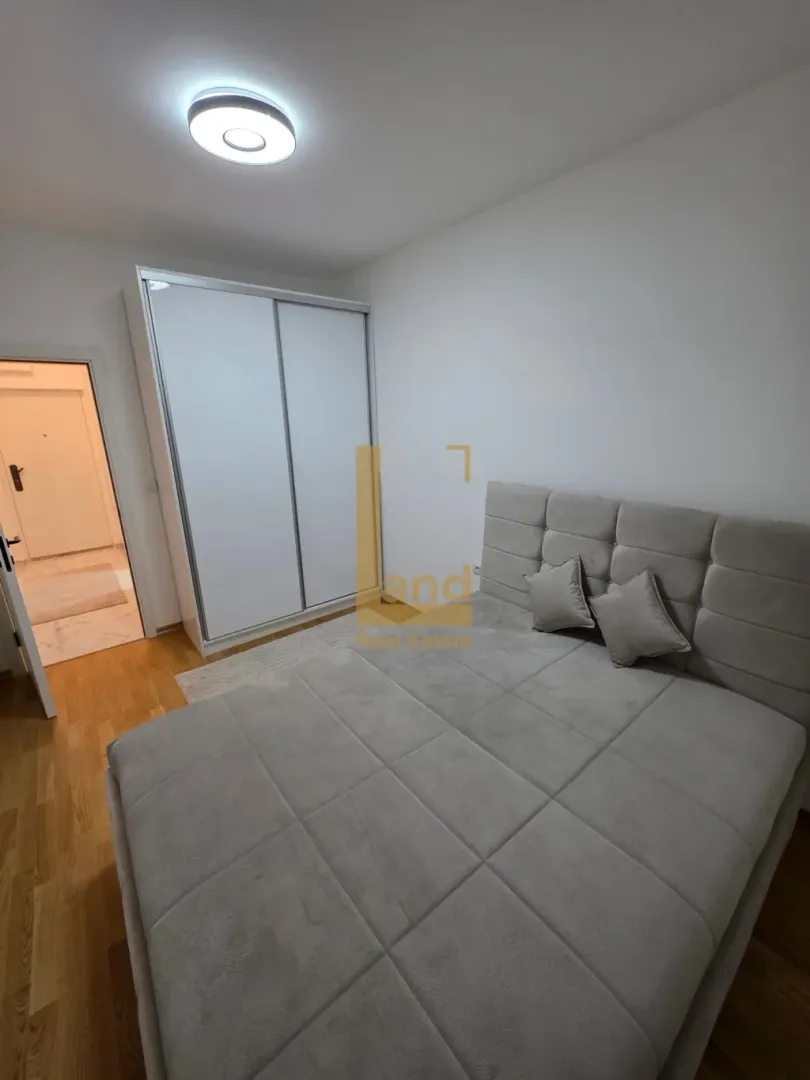 Furnished bedroom with a double bed and a fitted wardrobe.