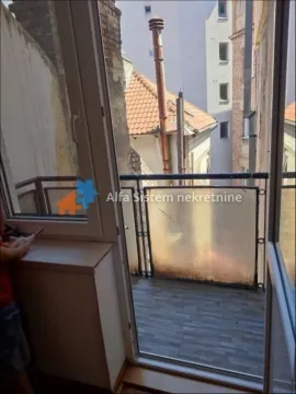 Pogled kroz balkonska vrata na manji spoljni balkon i okolne zgrade. - image 17