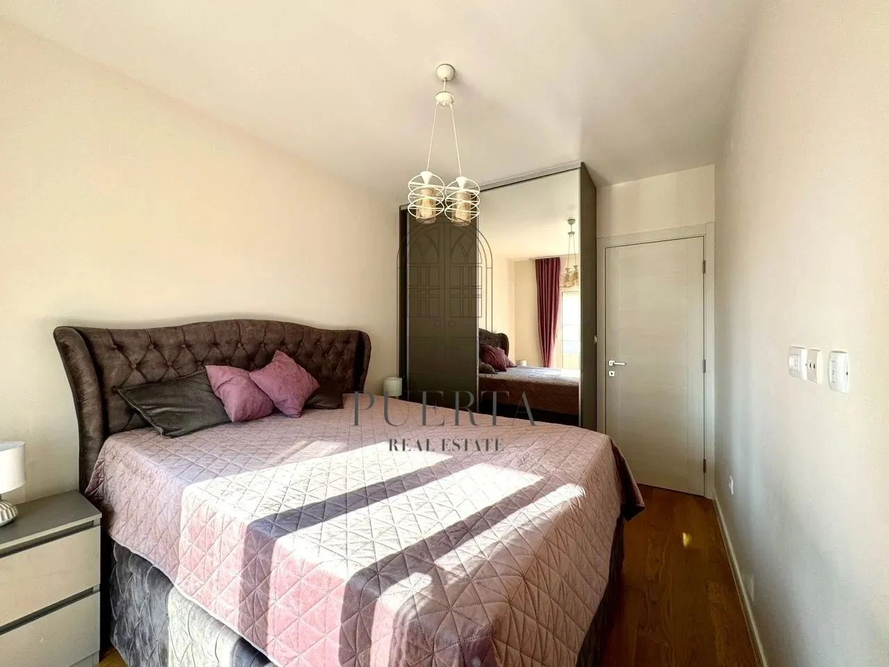 Furnished bedroom with a double bed and a wardrobe.