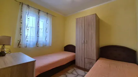 Spavaća soba sa dva kreveta i drvenim ormarom. - image 4