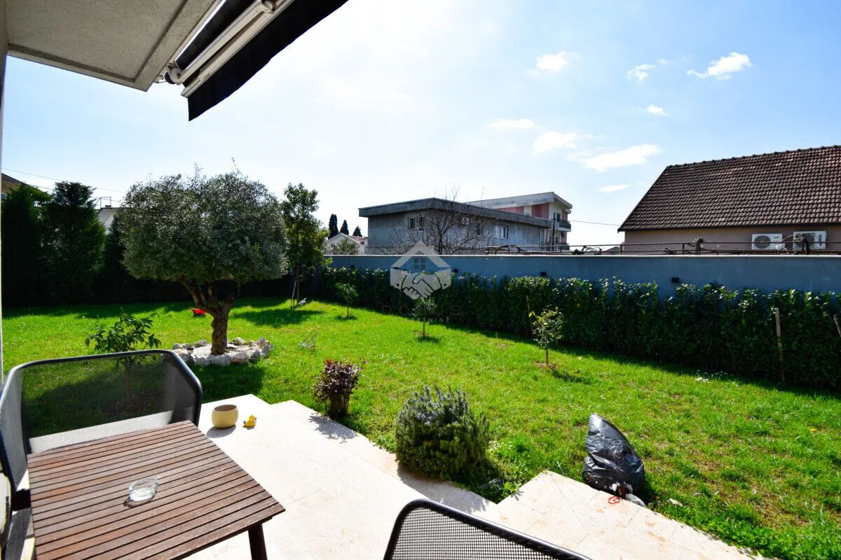 Terrace with a table and a view of the landscaped yard.