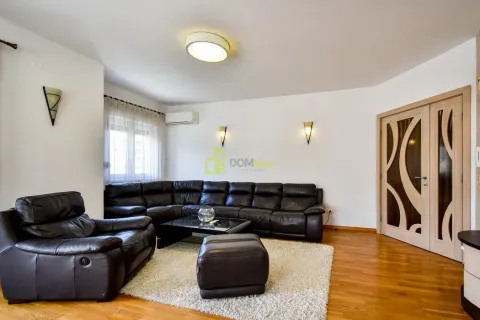 Spacious living room with a black leather sofa set and hardwood flooring. - image 6