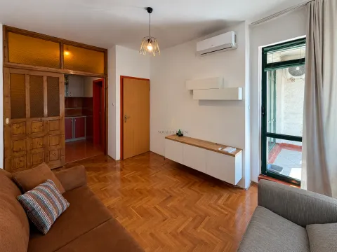 Living room with wooden parquet flooring, furniture, and access to the terrace. - image 2