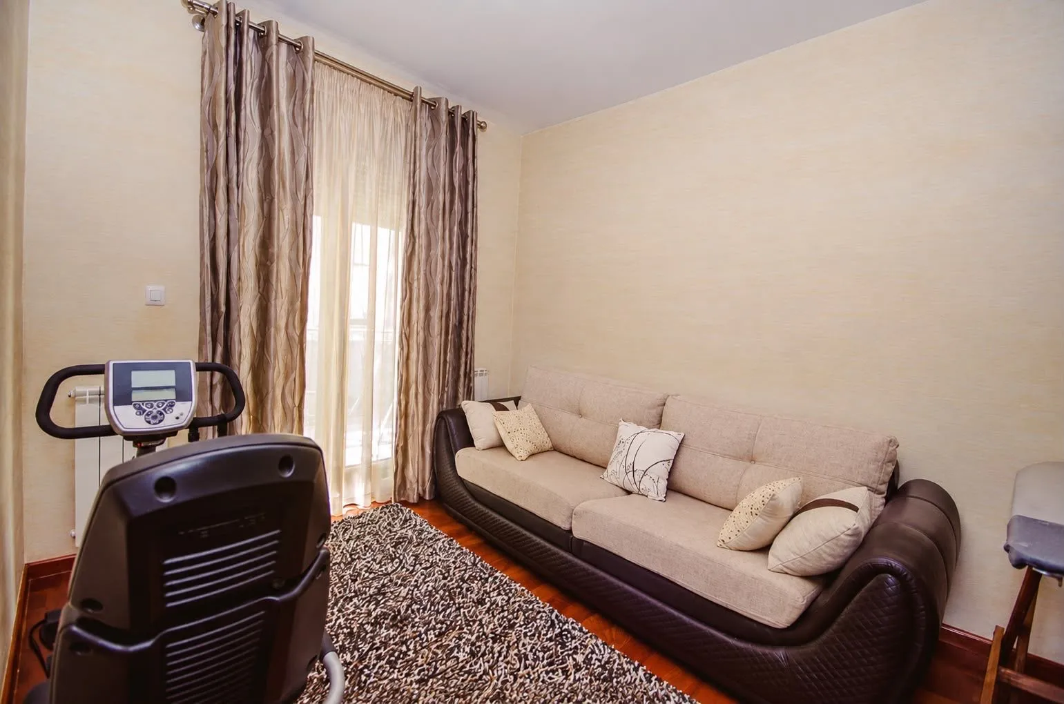 Living room with a sofa set and an exercise bike.