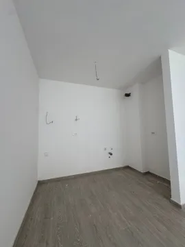 Prazna prostorija sa bijelim zidovima i laminatom na podu. - image 6