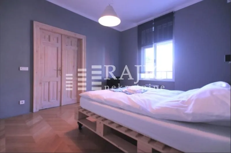 Bedroom with a double bed, wooden doors and parquet flooring.