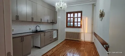 Kitchen with wooden cabinetry and parquet flooring. - image 12
