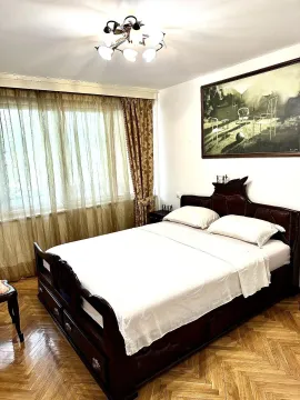 Svijetla spavaća soba sa velikim bračnim krevetom od tamnog drveta. - image 11