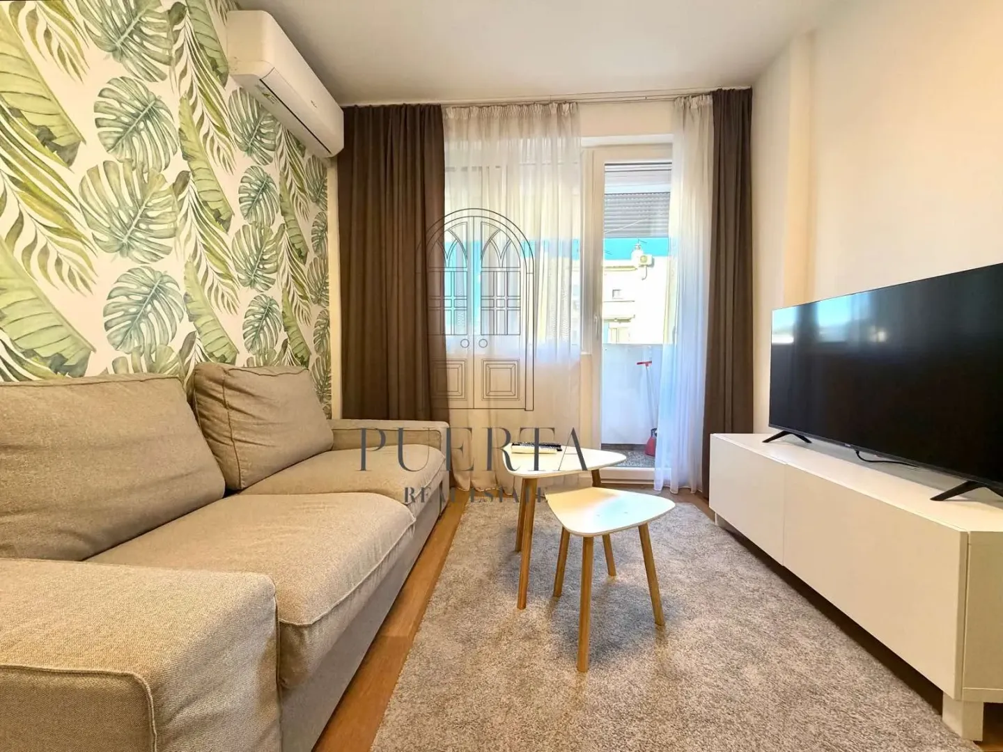 Living room with a sofa, TV, and access to the terrace.
