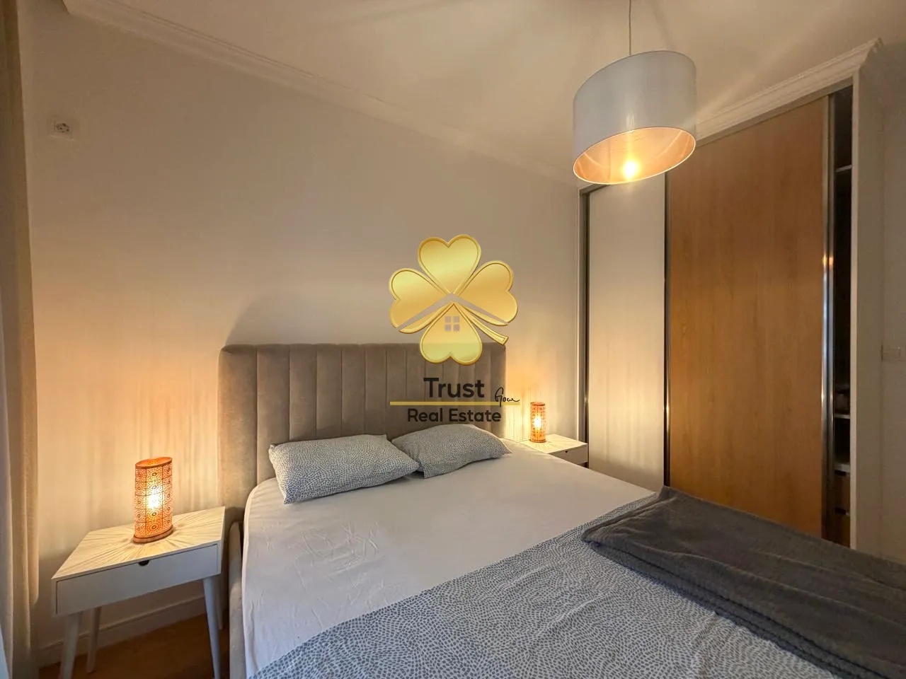 Furnished bedroom with a double bed, nightstands, and a wardrobe.