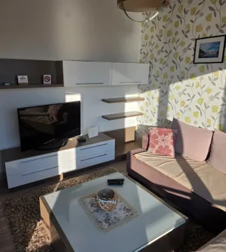 Living room with a sofa, TV unit and decorative wallpaper on the wall. - image 3