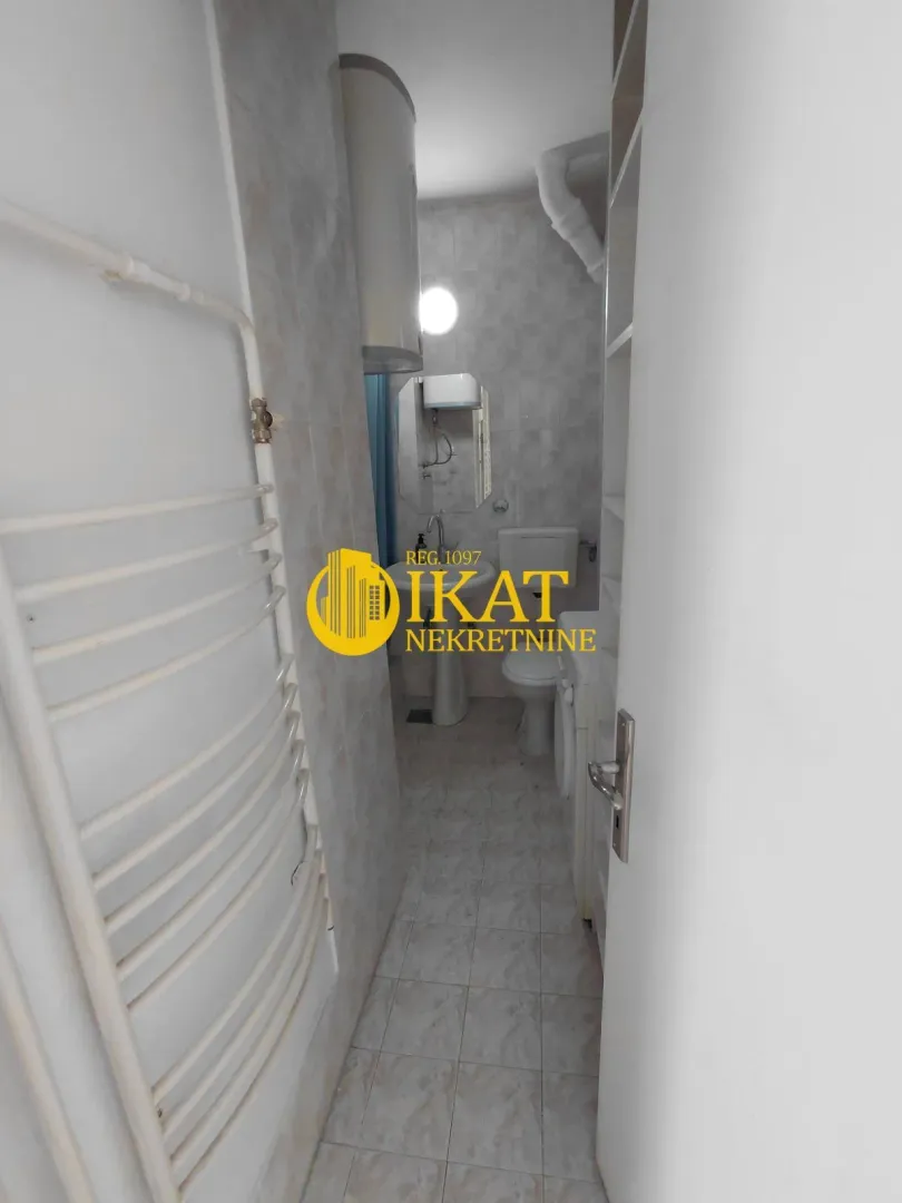 View of the bathroom with a sink, toilet, and radiator.