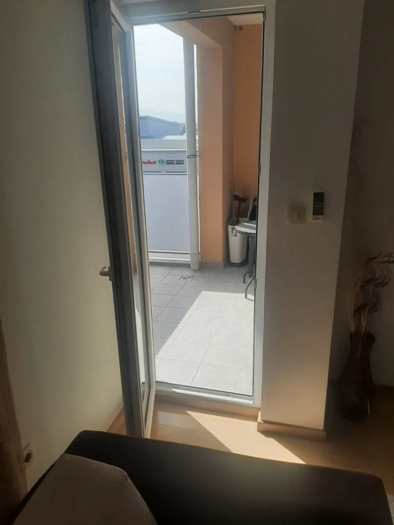 Open door leading to a tiled terrace.