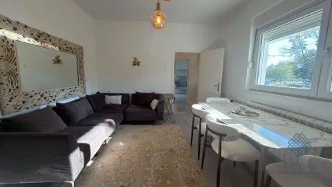 Dnevna soba sa ugaonom garniturom, trpezarijskim stolom i velikim ogledalom na zidu. - image 19