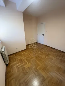 Empty room with hardwood parquet flooring and white door. - image 8