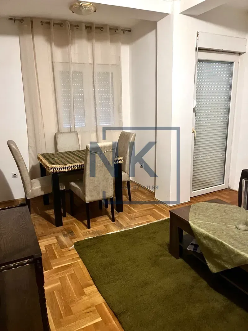 Living room with a dining area and parquet flooring.