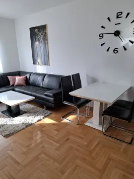Bright living room featuring a black leather sofa and a dining table. - image 7