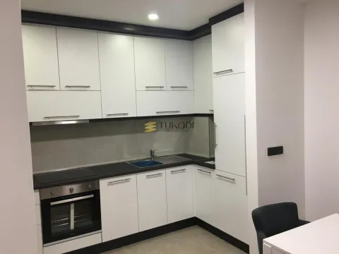 Moderna kuhinja u beloj boji sa crnim radnim površinama i ugrađenim aparatima. - image 4