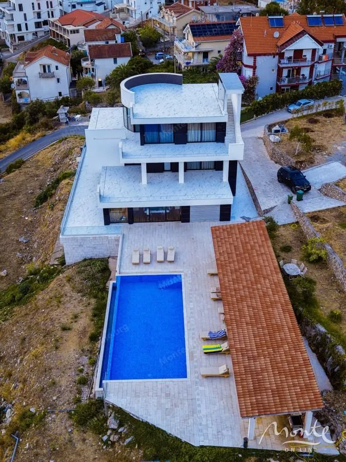 Aerial view of a modern villa with a swimming pool and sunbathing terrace.