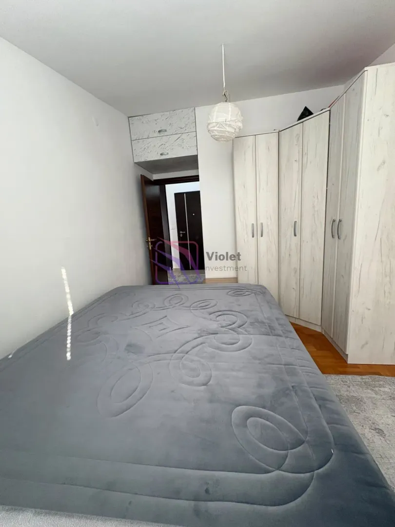 Bedroom with a double bed, wardrobe, and entrance door.