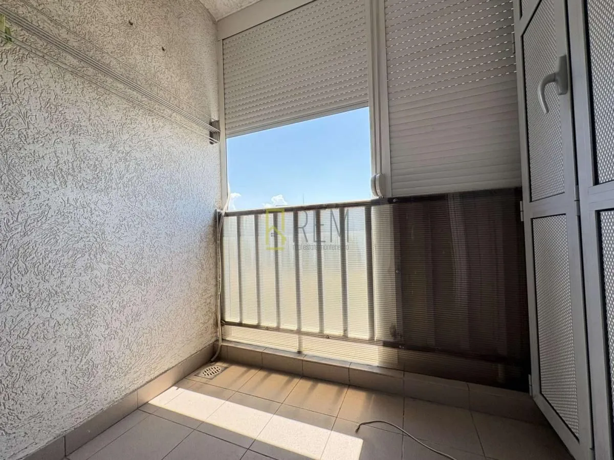Natkriveni balkon sa popločanim podom i zaštitnom ogradom.
