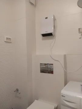 Dio kupatila sa bijelim keramičkim pločicama, wc šoljom i veš mašinom. - image 9