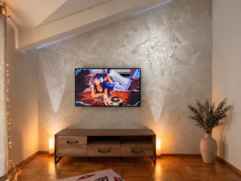 Living room with a wooden media console and a wall-mounted TV. - image 10
