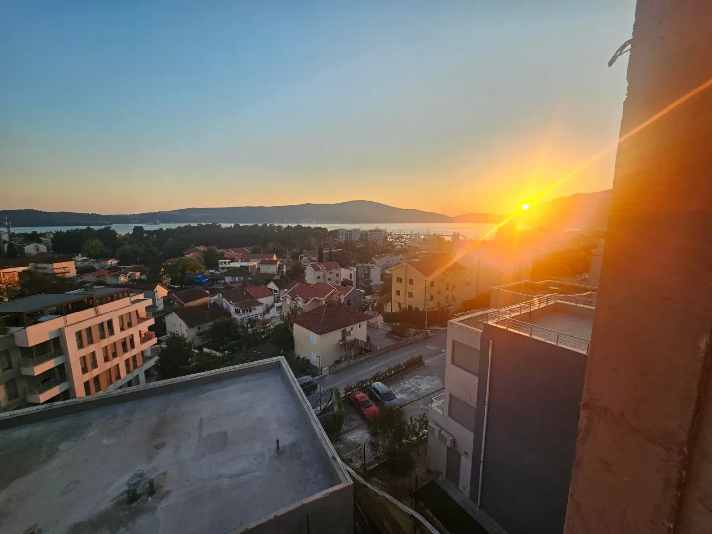 Pogled sa terase na naselje i zaliv u vrijeme zalaska sunca.