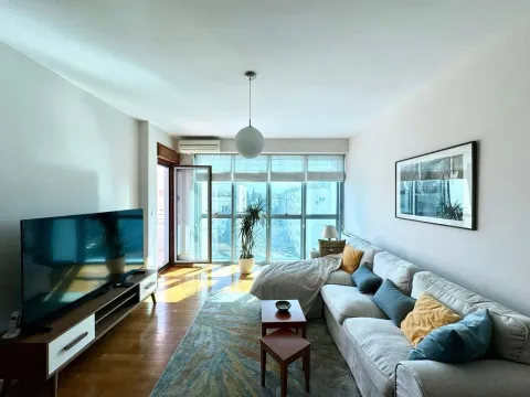 Bright living room with sofa, TV and large windows with a view. - image 2