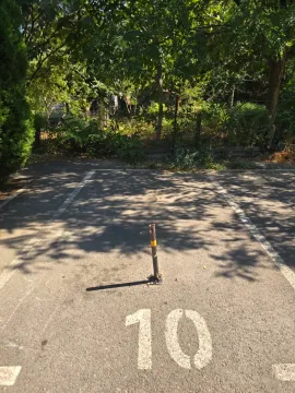Označeno parking mesto sa stubićem na otvorenom. - image 3
