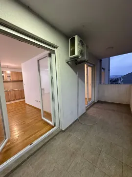 Natkrivena terasa sa spoljnom jedinicom klima uređaja i pogledom na unutrašnjost stana. - image 3