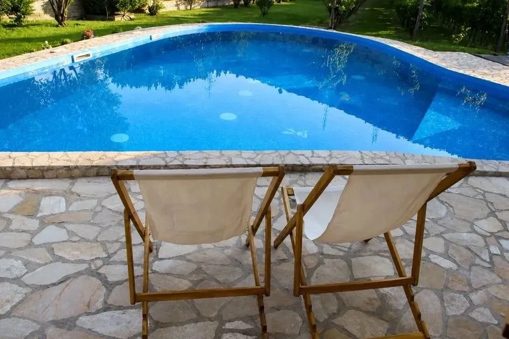 Yard with a swimming pool and sun loungers.