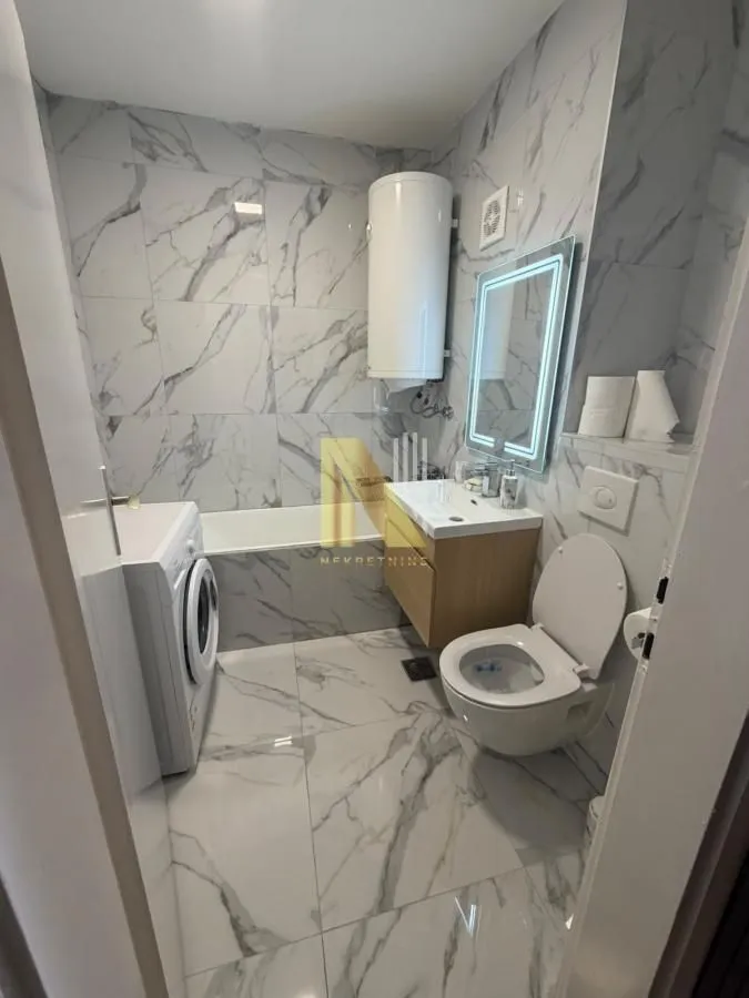 Moderno opremljeno kupatilo sa kadom, umivaonikom i wc šoljom.