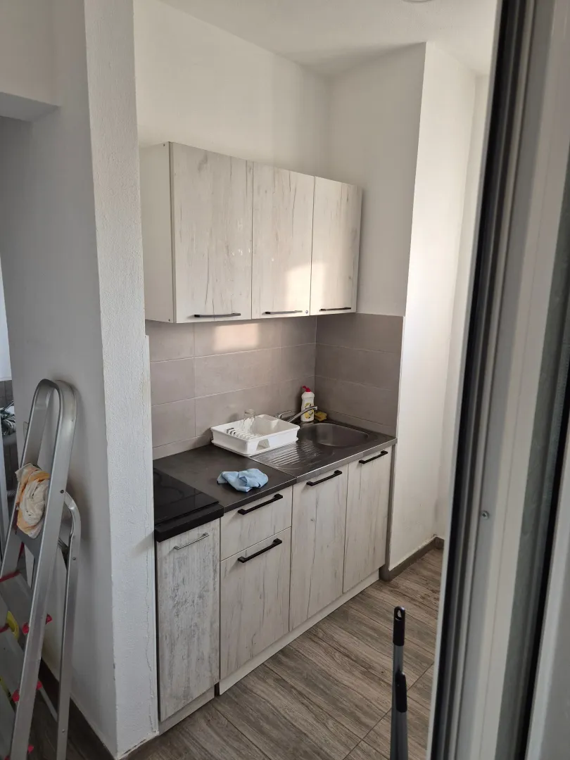 Small kitchen with light-colored cabinets and a sink.