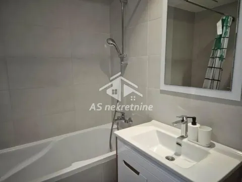 Bathroom equipped with a bathtub, washbasin, and mirror. - image 15
