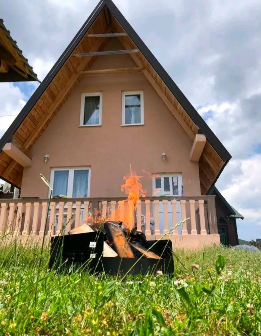 Eksterijer kuće sa dvorištem i mjestom za roštilj.