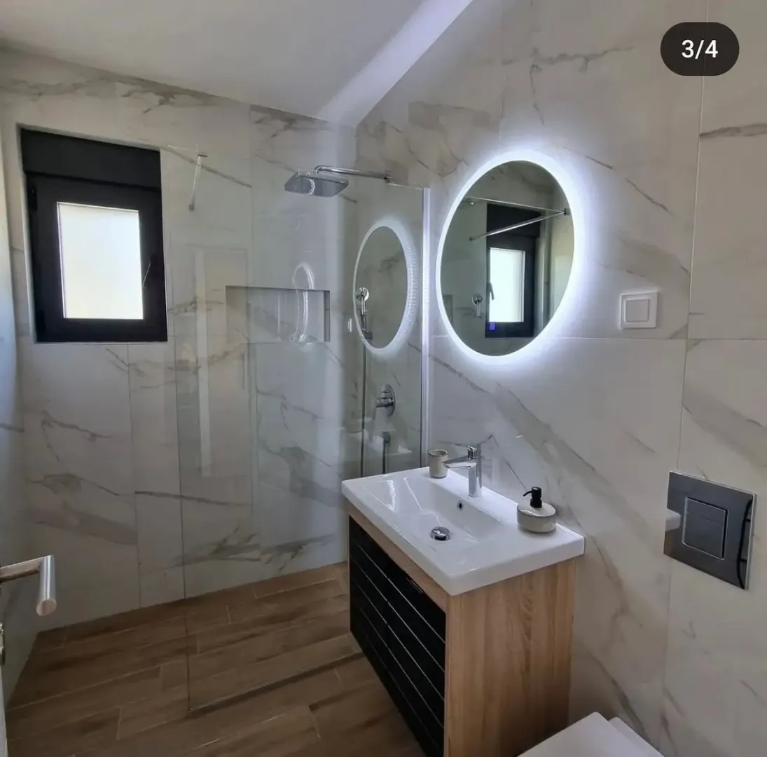 Modernly equipped bathroom with a walk-in shower and vanity.